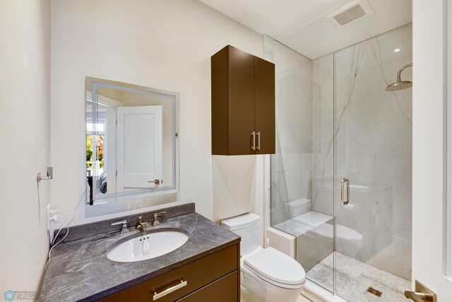 bathroom featuring vanity, toilet, and an enclosed shower