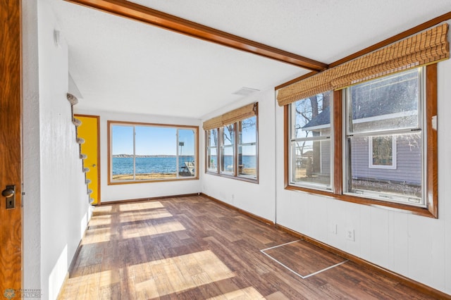 unfurnished sunroom featuring a healthy amount of sunlight and a water view