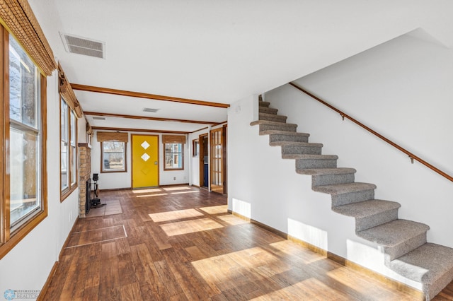 interior space with wood-type flooring and beam ceiling