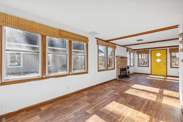 unfurnished sunroom featuring a wood stove and a fireplace