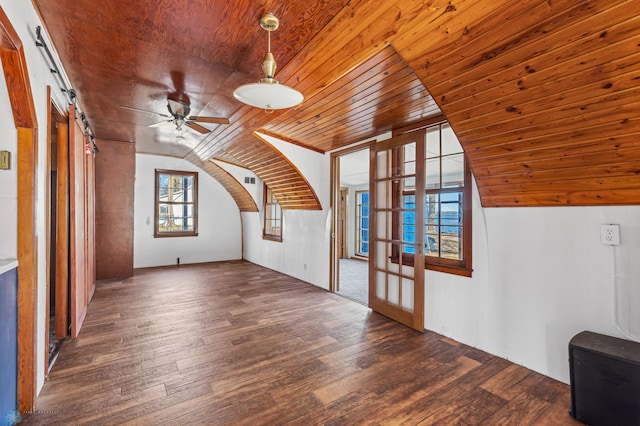 bonus room with dark hardwood / wood-style flooring, a barn door, vaulted ceiling, wood ceiling, and ceiling fan