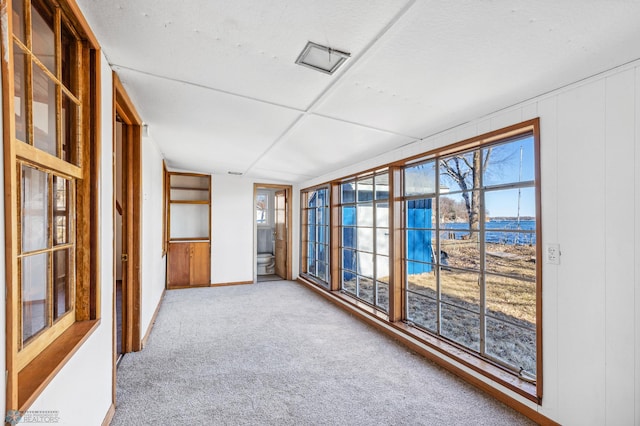 empty room with light colored carpet and a water view