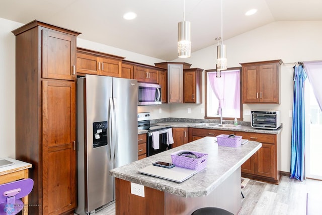 kitchen with a center island, sink, light hardwood / wood-style floors, stainless steel appliances, and a kitchen breakfast bar