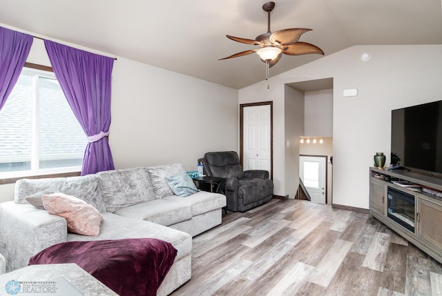 living room featuring vaulted ceiling, light hardwood / wood-style flooring, and ceiling fan