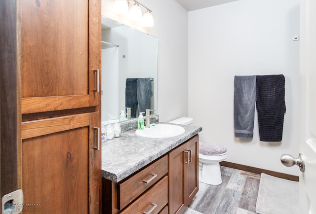 bathroom with hardwood / wood-style floors, vanity, and toilet