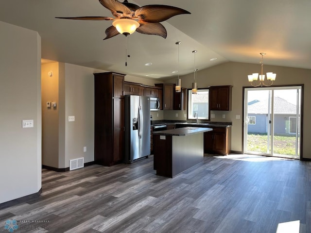 kitchen with appliances with stainless steel finishes, a center island, decorative light fixtures, lofted ceiling, and dark hardwood / wood-style floors