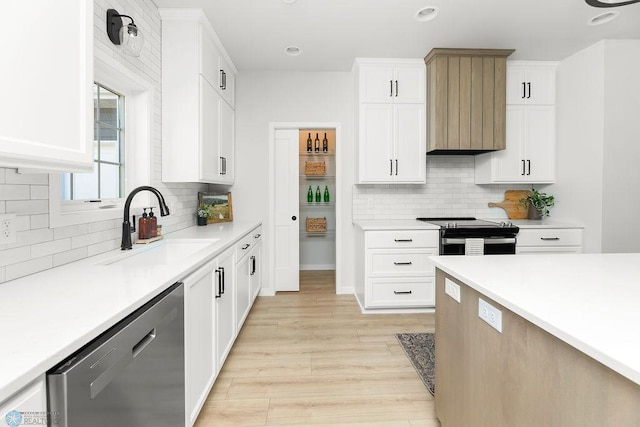 kitchen featuring stainless steel appliances, light hardwood / wood-style floors, tasteful backsplash, white cabinetry, and sink