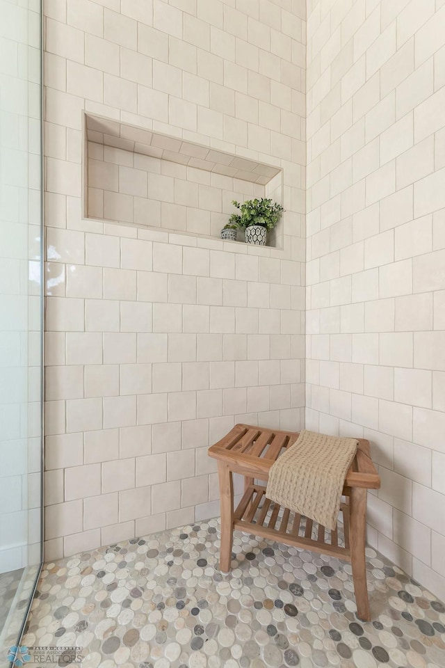 bathroom with tile walls and a tile shower