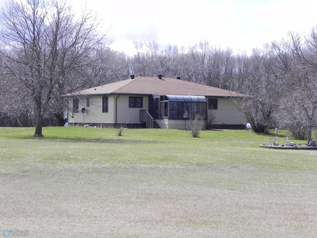 single story home featuring a sunroom and a front lawn