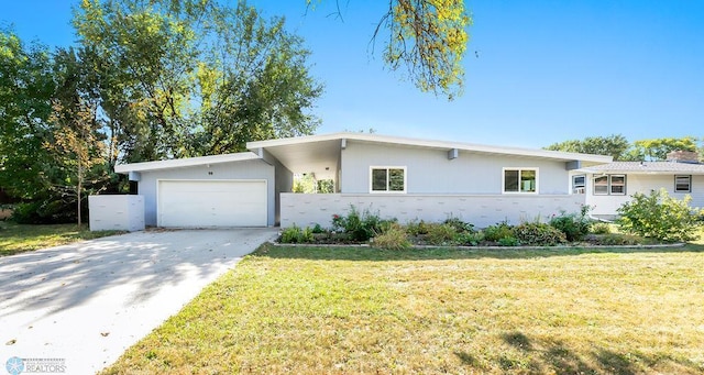 ranch-style house featuring a front yard and a garage