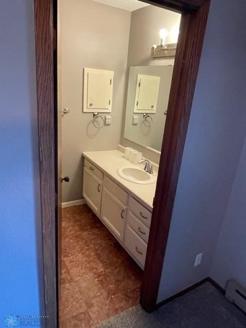 bathroom featuring baseboard heating, tile floors, and vanity