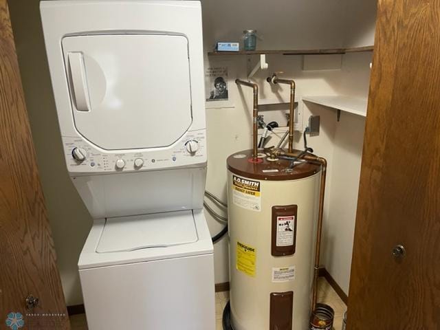 clothes washing area featuring tile floors, stacked washing maching and dryer, and electric water heater