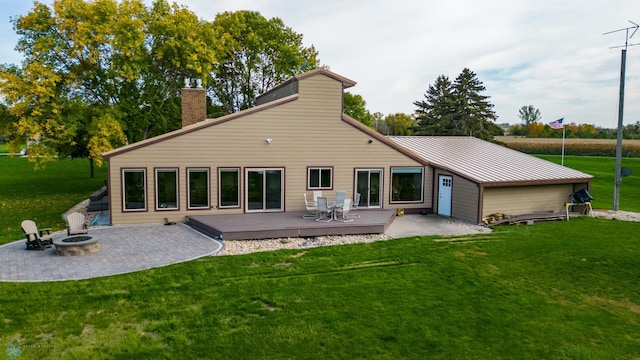 rear view of house featuring a patio area, an outdoor fire pit, a deck, and a lawn