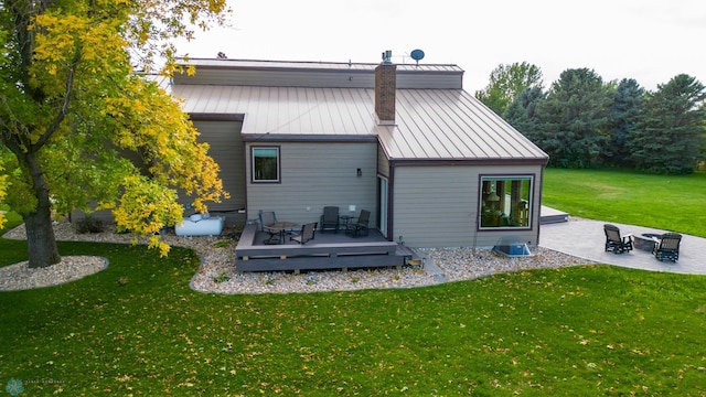 back of house with a deck, a patio, and a lawn