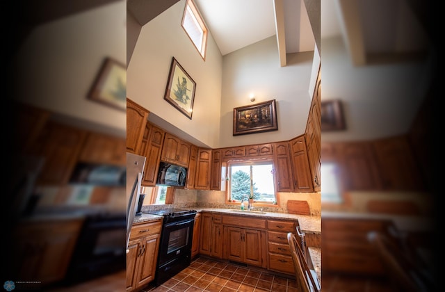 kitchen with high vaulted ceiling, sink, dark tile flooring, tasteful backsplash, and black appliances