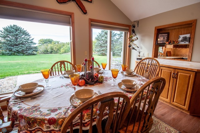 dining room featuring vaulted ceiling and hardwood / wood-style flooring