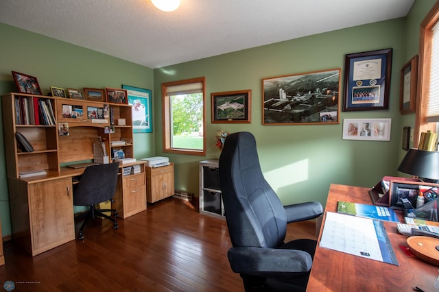 office area with a textured ceiling and dark wood-type flooring