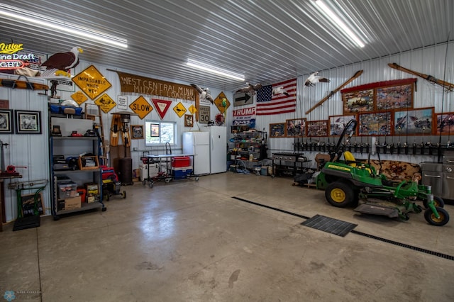 garage featuring white refrigerator and a workshop area