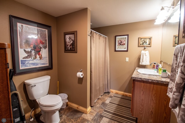 bathroom with tile floors, vanity, and toilet