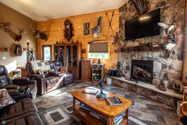 tiled living room with wooden walls and a stone fireplace