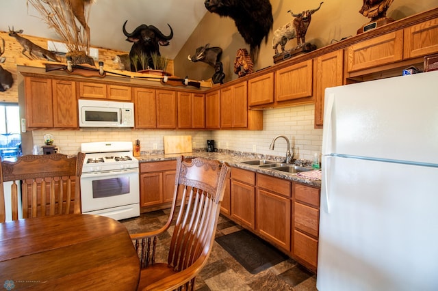 kitchen with tasteful backsplash, dark tile floors, white appliances, and sink