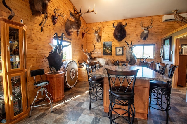 dining room featuring wooden walls, dark tile flooring, and a wall mounted AC