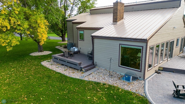 exterior space featuring a deck, a yard, and central air condition unit