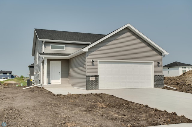 view of front of home with a garage and central air condition unit