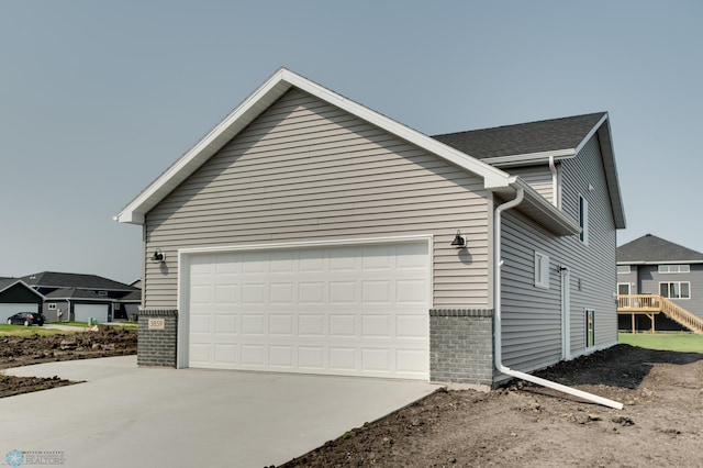 view of home's exterior with a deck and a garage