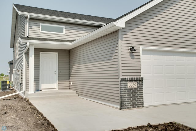 doorway to property with cooling unit and a garage