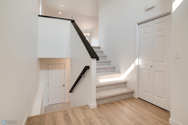 stairs featuring a chandelier and light wood-type flooring