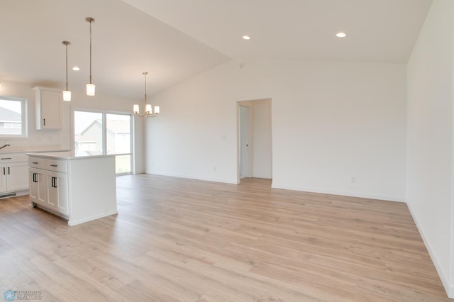 kitchen featuring light hardwood / wood-style flooring, lofted ceiling, and white cabinets