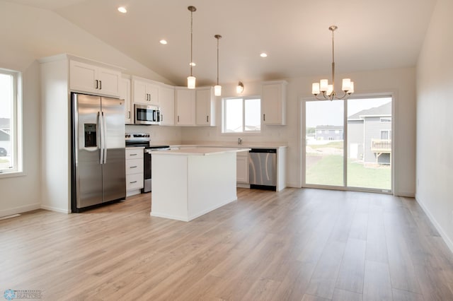 kitchen with a kitchen island, appliances with stainless steel finishes, light hardwood / wood-style floors, and white cabinetry