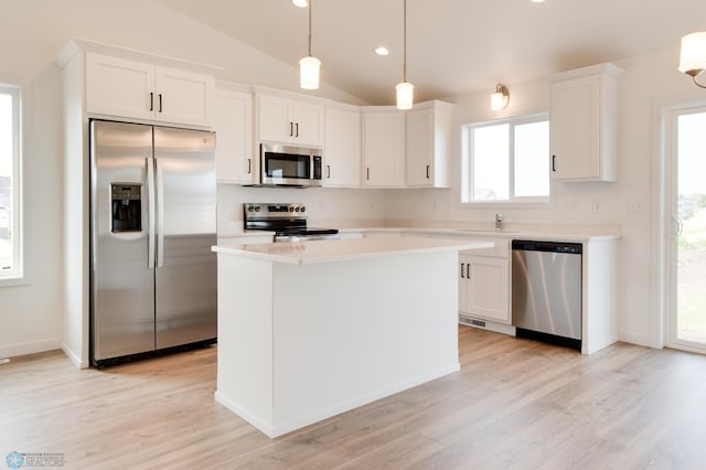 kitchen with white cabinetry, stainless steel appliances, vaulted ceiling, and light hardwood / wood-style flooring