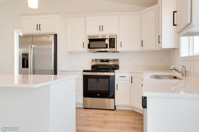 kitchen featuring white cabinets, stainless steel appliances, and light wood-type flooring