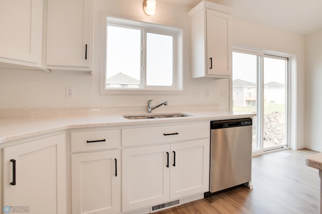 kitchen with sink, dishwasher, light wood-type flooring, and a wealth of natural light