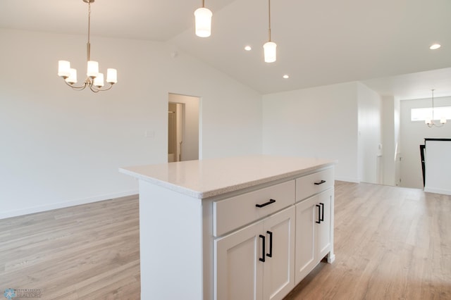 kitchen with lofted ceiling, hanging light fixtures, white cabinets, and light hardwood / wood-style floors