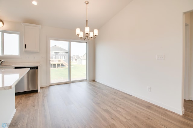 unfurnished dining area with sink, a wealth of natural light, and light wood-type flooring