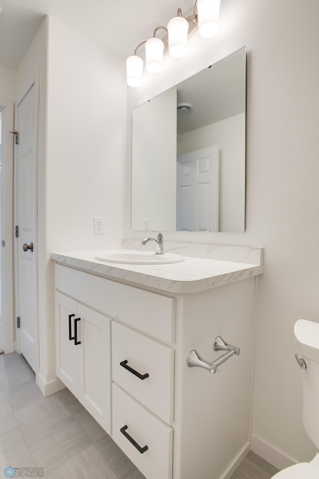 bathroom featuring vanity, tile patterned flooring, and toilet