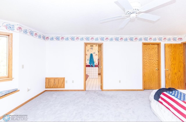 unfurnished bedroom featuring carpet flooring, ceiling fan, and ensuite bath