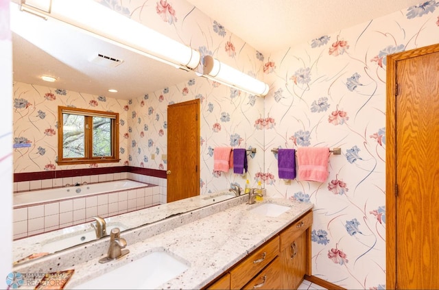 bathroom with dual bowl vanity and tiled tub