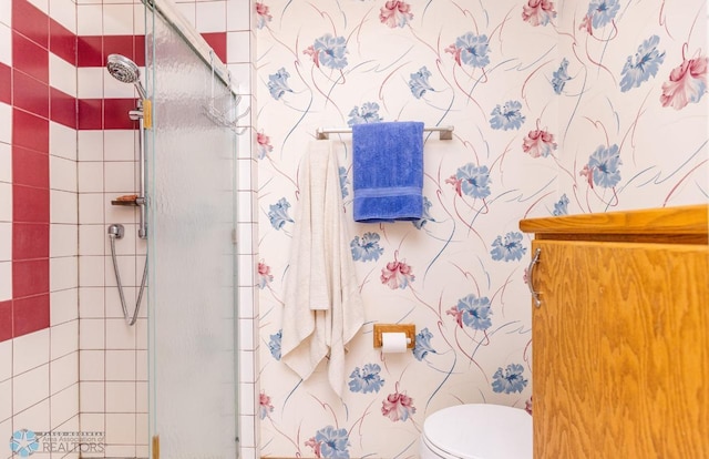 bathroom with a shower with door and toilet