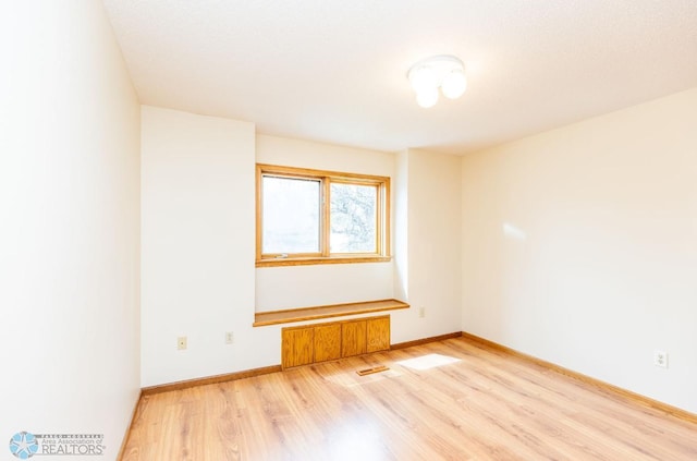 spare room with light hardwood / wood-style floors and radiator