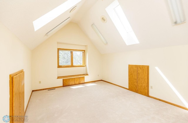 bonus room with carpet floors and lofted ceiling with skylight