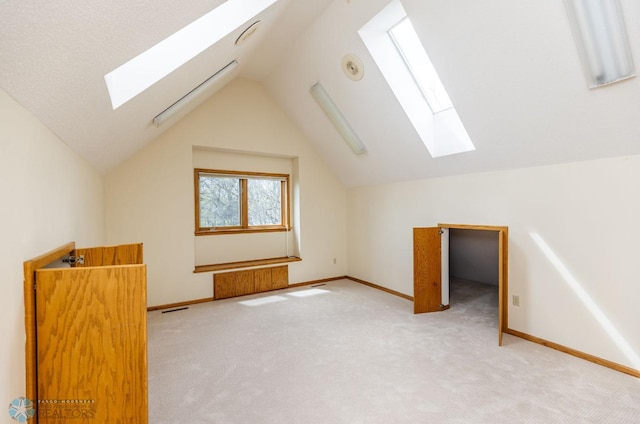 bonus room with carpet flooring and lofted ceiling with skylight