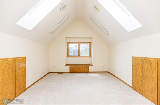 bonus room featuring vaulted ceiling with skylight and carpet flooring