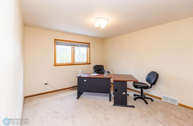 carpeted office space with a textured ceiling