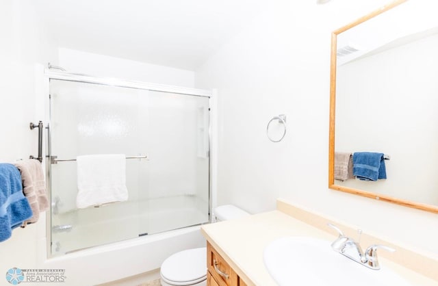 full bathroom featuring bath / shower combo with glass door, vanity, and toilet