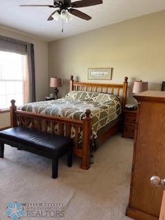 bedroom featuring light colored carpet and ceiling fan