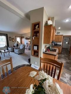 carpeted dining area with beam ceiling